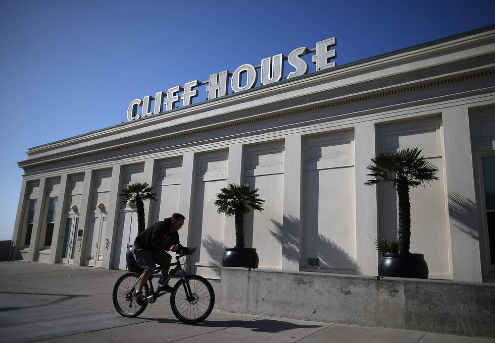 A cyclist rides by the Cliff House restaurant on October 10, 2013 in San Francisco, California.