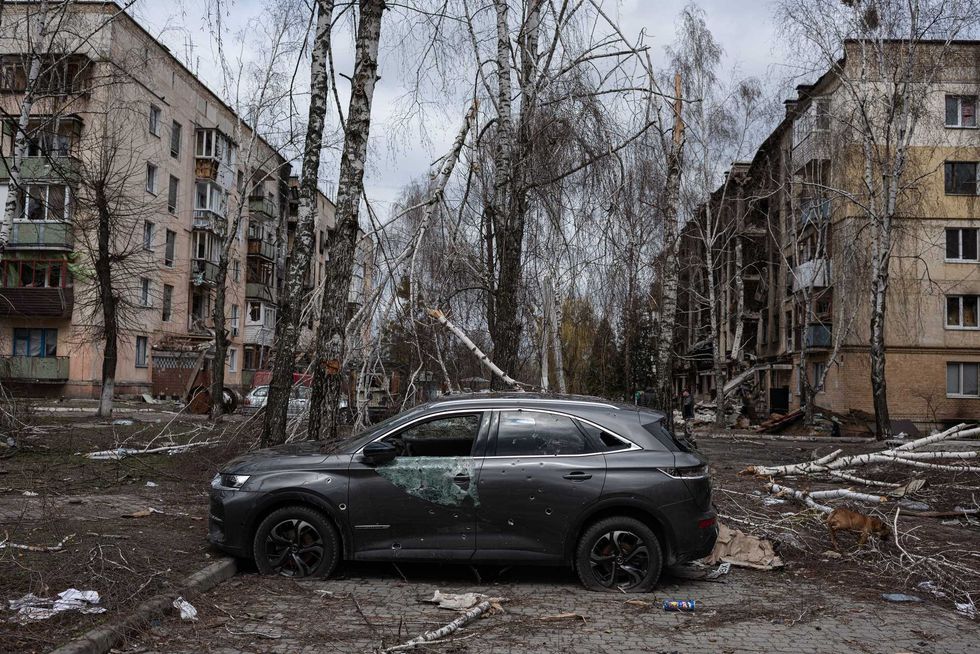 A damaged car is seen next to a heavily damaged apartment building on April 6, 2022 in Hostomel, Ukraine