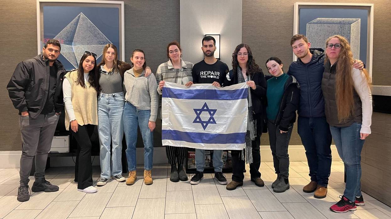 A delegation of Israeli students that visited the Philadelphia area, holding an Israeli flag.