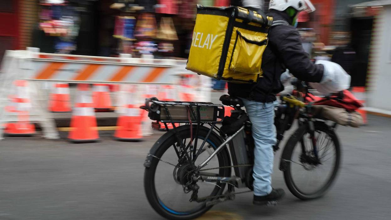 A delivery person rides an electric bicycle through the streets of Manhattan on November 15, 2022 in New York City.
