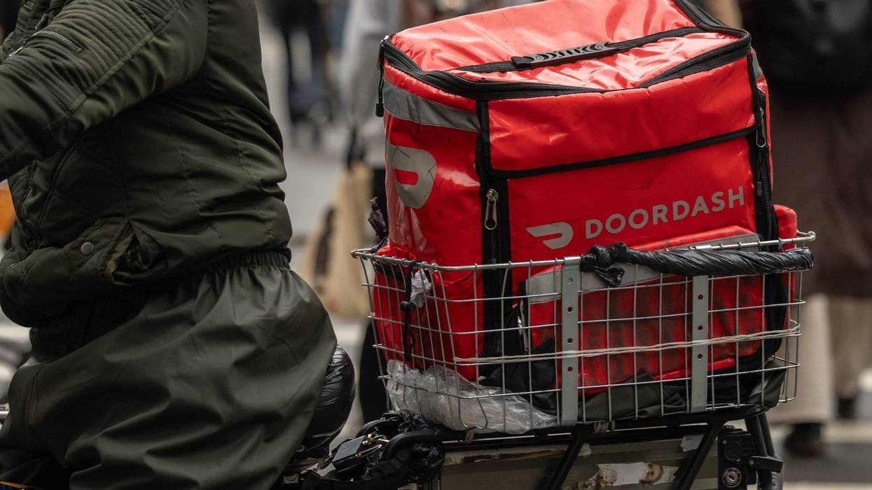 A delivery worker carries a DoorDash bag during a delivery in New York.