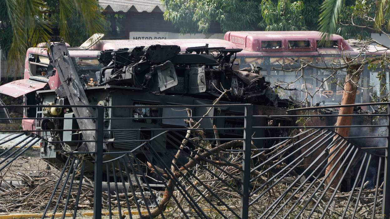 A destroyed armored vehicle sits at La Carlota airport in Caracas, Venezuela, Saturday, Jan. 3, 2026, after explosions were reported at the site.