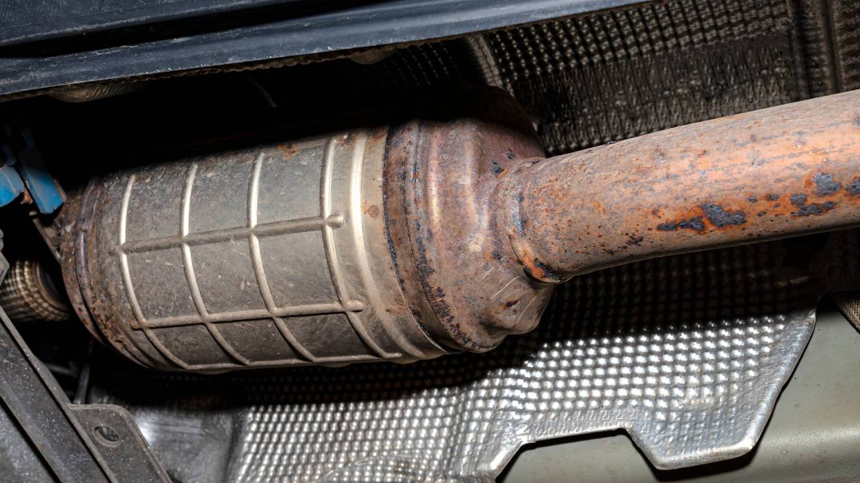 A diesel particulate filter in the exhaust system in a car on a lift in a car workshop