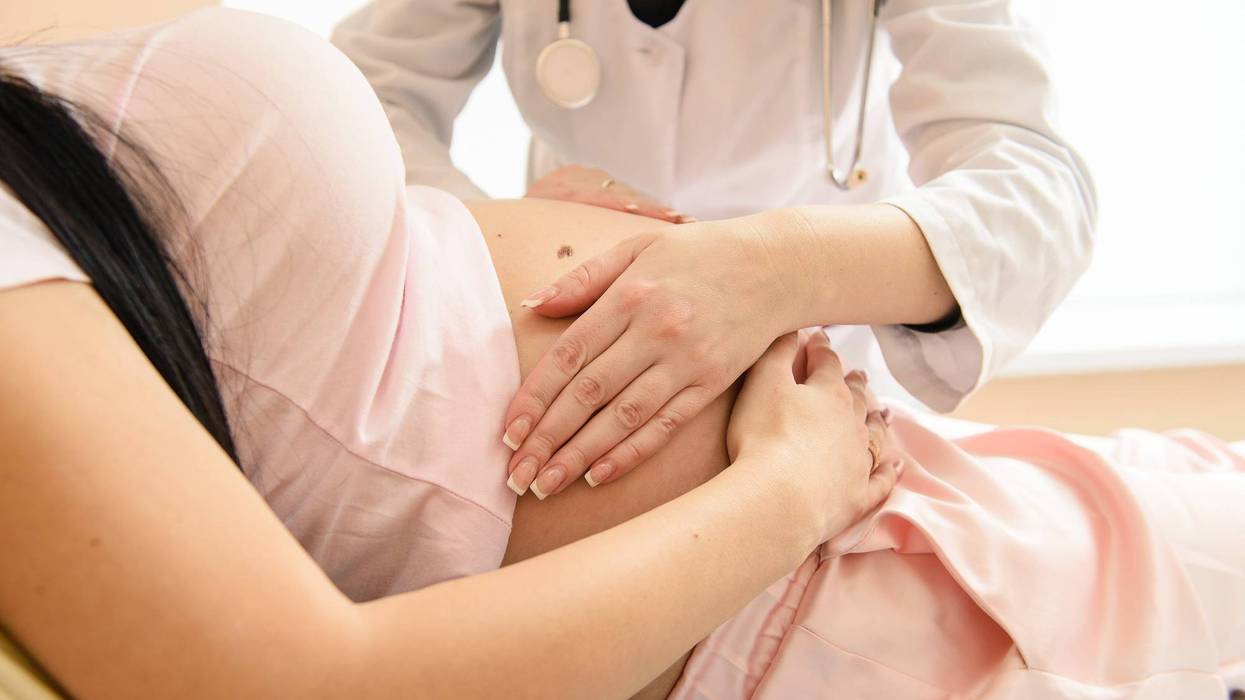 A doctor performs a check up on a pregnant patient.