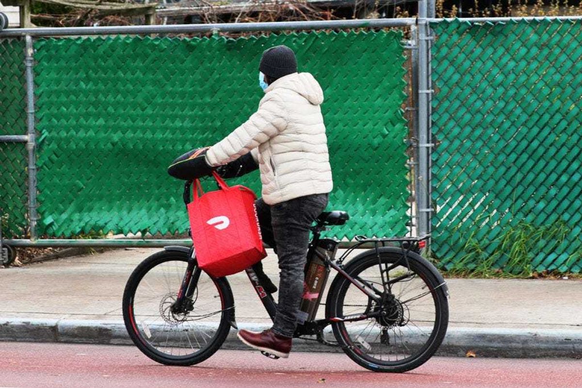 A Doordash delivery person rides their bike on Church Avenue in the Flatbush neighborhood of Brooklyn on December 04, 2020 in New York City. Food delivery startup DoorDash Inc is expected to raise its U.S. initial public offering up to $3.14 billion. (Photo by Michael M. Santiago/Getty Images)
