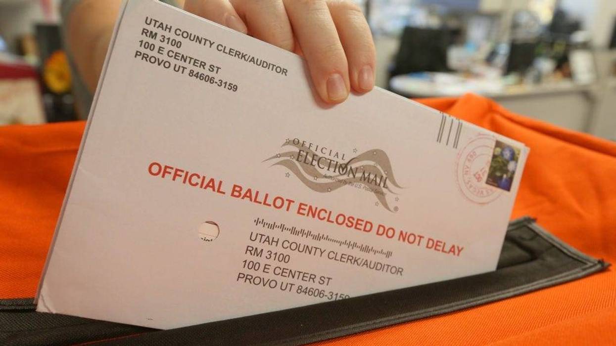 A employee at the Utah County Election office puts mail in ballots into a container to register the vote in the midterm elections on November 6, 2018 in Provo, Utah