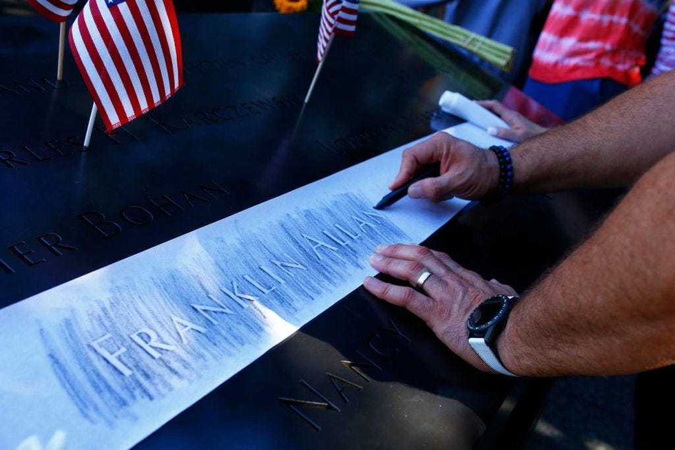 A family member etches the name of a loved one during the annual 9/11 Commemoration Ceremony at the National 9/11 Memorial and Museum on September 11, 2021 in New York City.