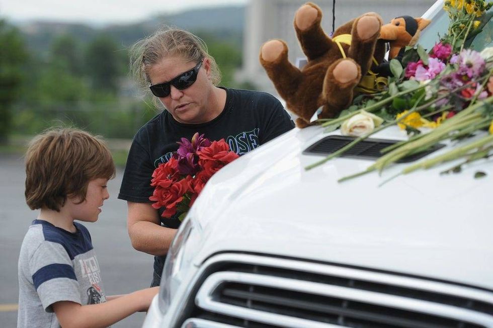 A family places flowers on vehicles of the victims of the Ride The Ducks accident on July 20, 2018 in Branson, Missouri.