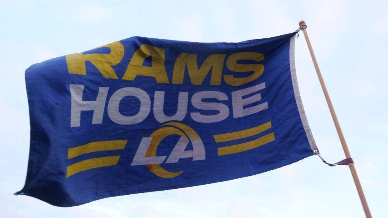 A fan holds up a flag that reads "Rams House" during the Los Angeles Rams Draft Experience presented by SoFi on April 25, 2024 in Hermosa Beach, California.