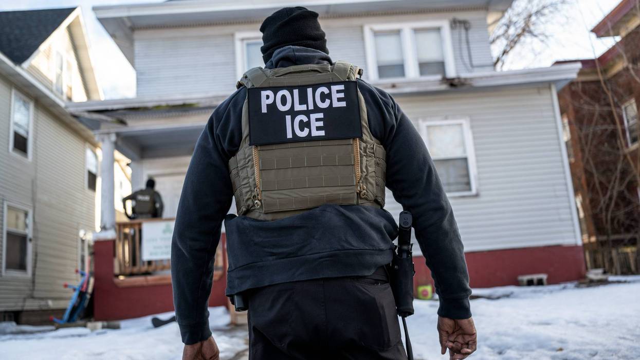 A federal law enforcement agent outside a home during a raid in south Minneapolis, Minnesota, US, on Tuesday, Jan. 13, 2026