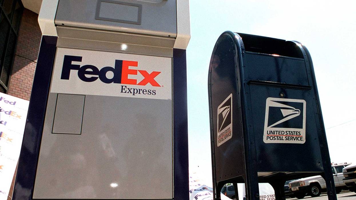 A FedEx drop box sits next to a US mail box at the announcement of FedEx and the US Postal Service''s business aggreement June 19, 2001 in Washington, DC.