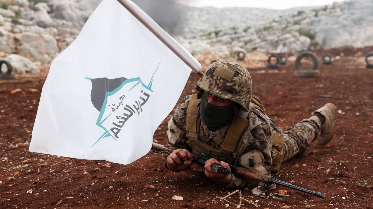 A fighter affiliated with Syria's "Hayat Tahrir al-Sham" (HTS) rebel-group, takes part in a military excercise on attacking tactics with live ammunition, on the outskirts of the northwestern province of Idlib, on November 8, 2022. - The last pocket of armed opposition to Syrian President Bashar al-Assad's regime includes large swathes of Idlib province and parts of the neighbouring Aleppo, Hama and Latakia provinces. Hayat Tahrir al-Sham (HTS), headed by ex-members of Syria's former Al-Qaeda franchise, is the dominant group in the area but other rebel groups are also active.