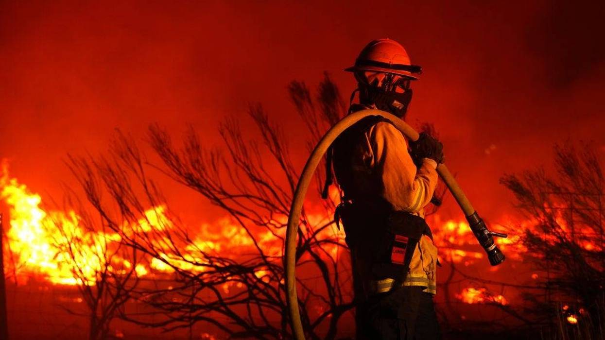 A firefighter monitors the Dixie Fire as it burns close to a home on August 16, 2021 near Janesville, California.