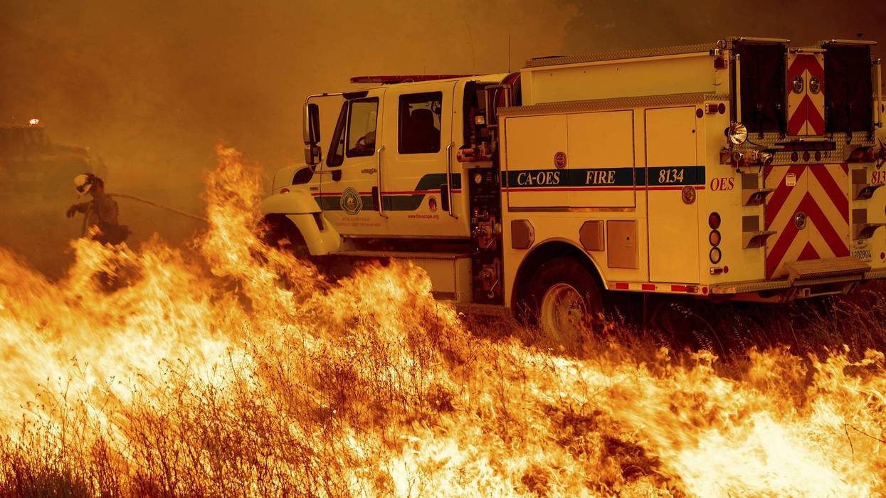 A firefighter scrambles to stop the Pawnee fire as it spots across Highway 20 near Clearlake Oaks, Calif., on Sunday, July 1, 2018.