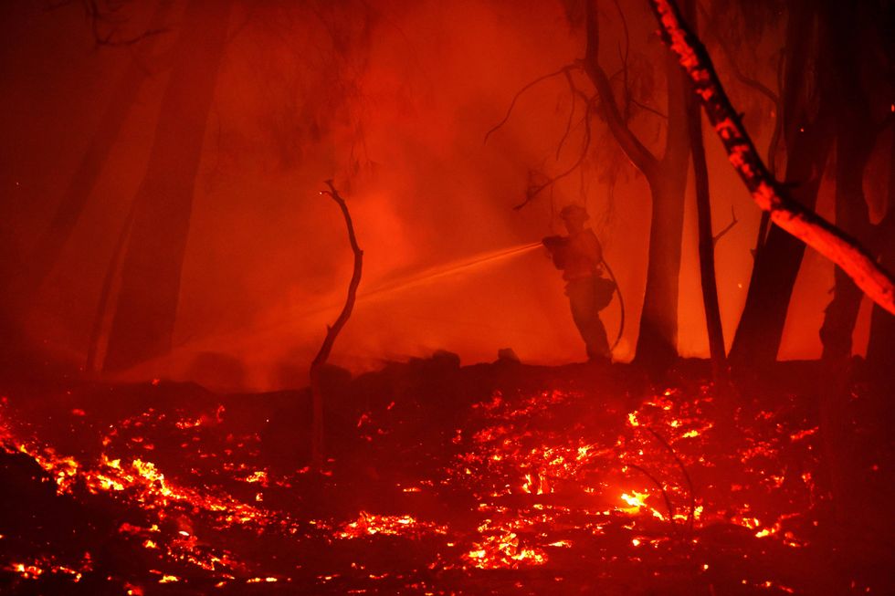 A firefighter sprays water on hot spots while battling the Glass Fire on October 01, 2020 in Calistoga, California.
