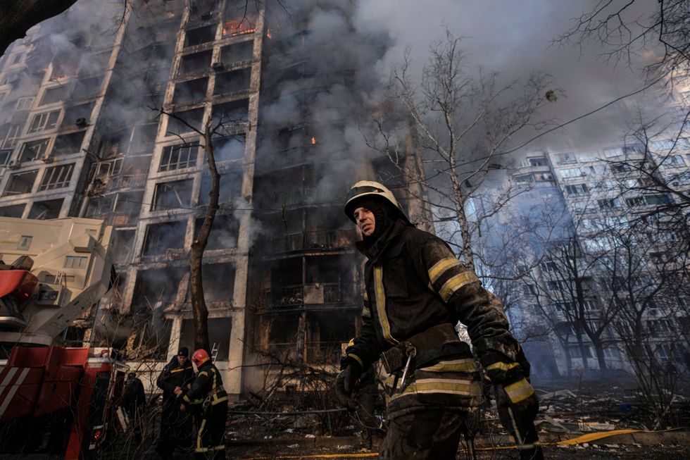 A firefighter walks outside a destroyed apartment building after a bombing in a residential area in Kyiv, Ukraine, Tuesday, March 15, 2022