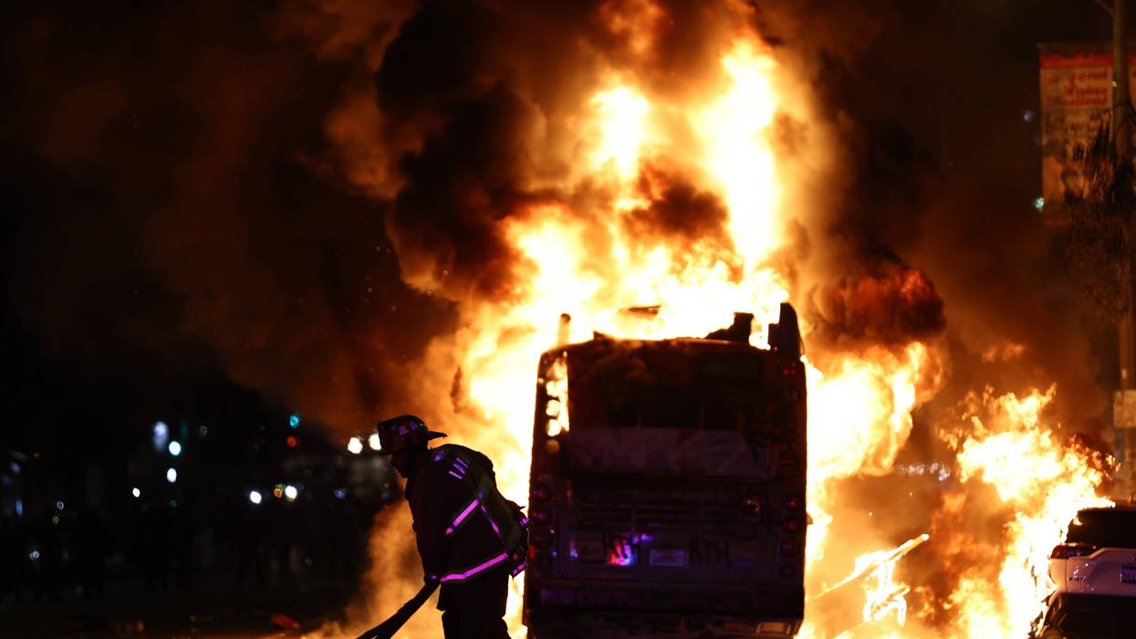 A firefighter works as a Metro bus burns following Dodger fan celebrations in the area which turned unruly, after the Los Angeles Dodgers defeated the New York Yankees in Game 5 to win the World Series, on October 31, 2024 in Los Angeles, California.