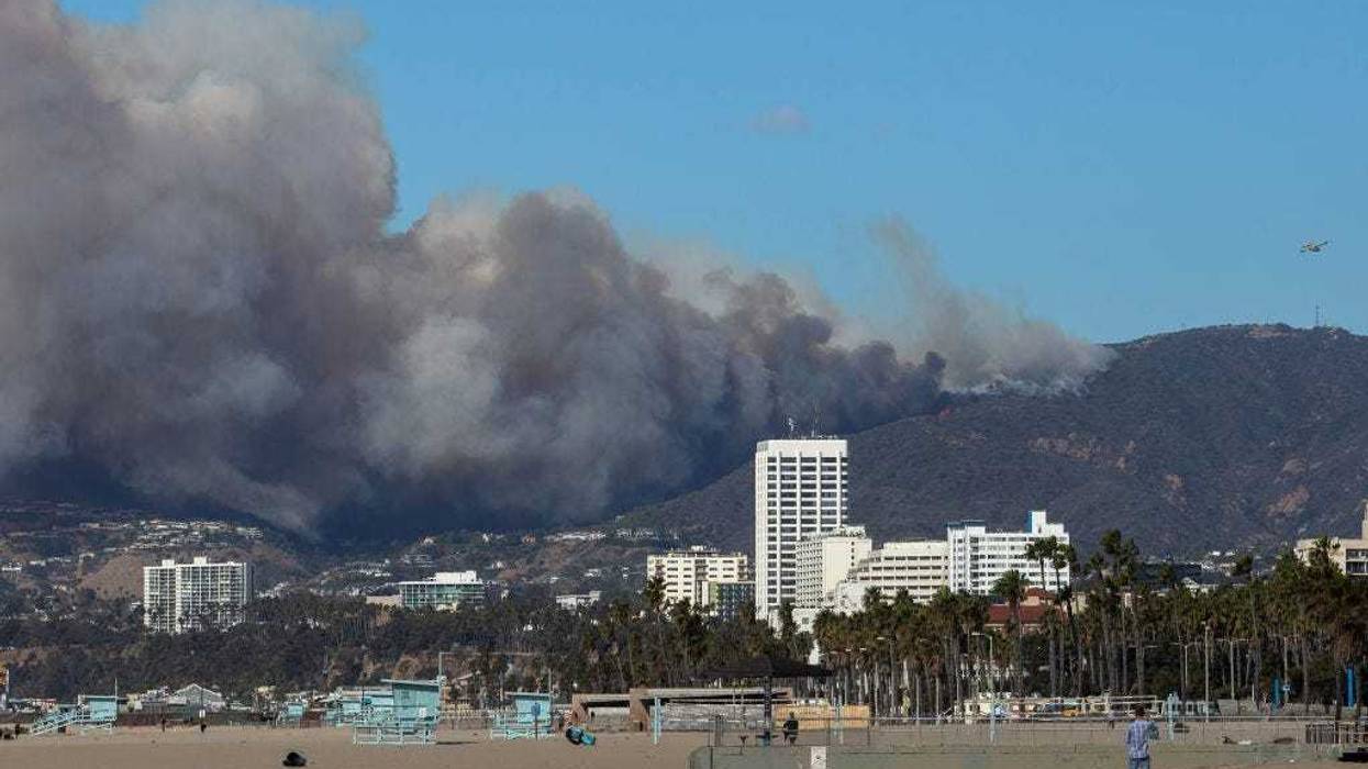 A firefighting aircraft drops the fire retardant Phos-Chek as the Palisades Fire burns amid a powerful windstorm on January 7, 2025 in the Pacific Palisades neighborhood of Los Angeles, California.