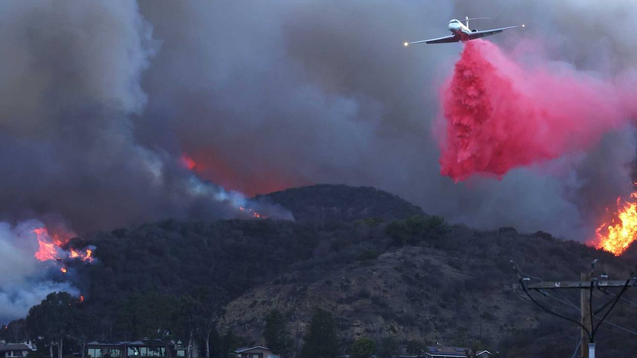 A firefighting aircraft drops the fire retardant Phos-Chek as the Palisades Fire burns amid a powerful windstorm on January 7, 2025 in Pacific Palisades, California.