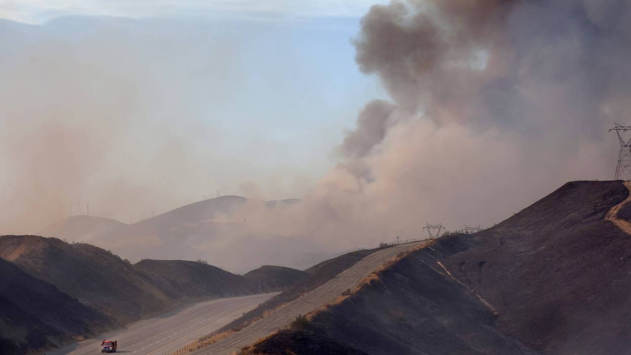 A firefighting helicopter drops water near a hotspot along a reopened section of the 5 freeway which was closed yesterday as the Route Fire burned on September 1, 2022 near Castaic, California.