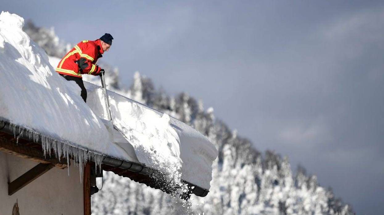 A fireman clears a roof following heavy snowfall in the area on January 12, 2019 in Kruen, Germany.