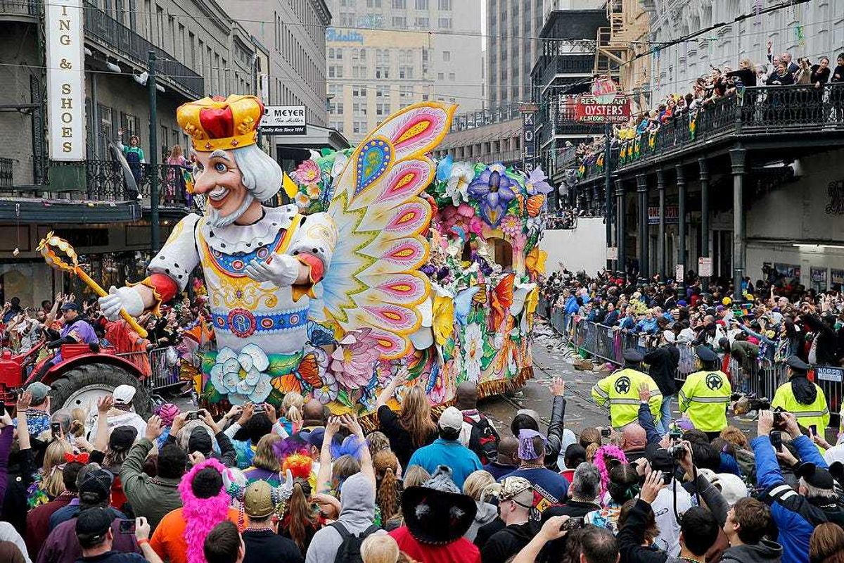 A float in the Rex parade turns on to Canal Street to large crowds with out outstretched arms on Mardi Gras Day. New Orleans prevented a parade from going down the street this week due to police staffing issues.