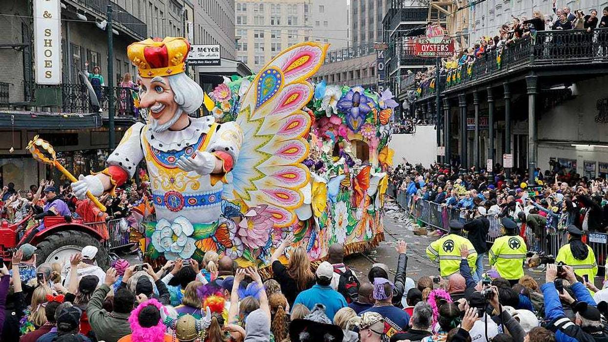 A float in the Rex parade turns on to Canal Street to large crowds with out outstretched arms on Mardi Gras Day. New Orleans prevented a parade from going down the street this week due to police staffing issues.