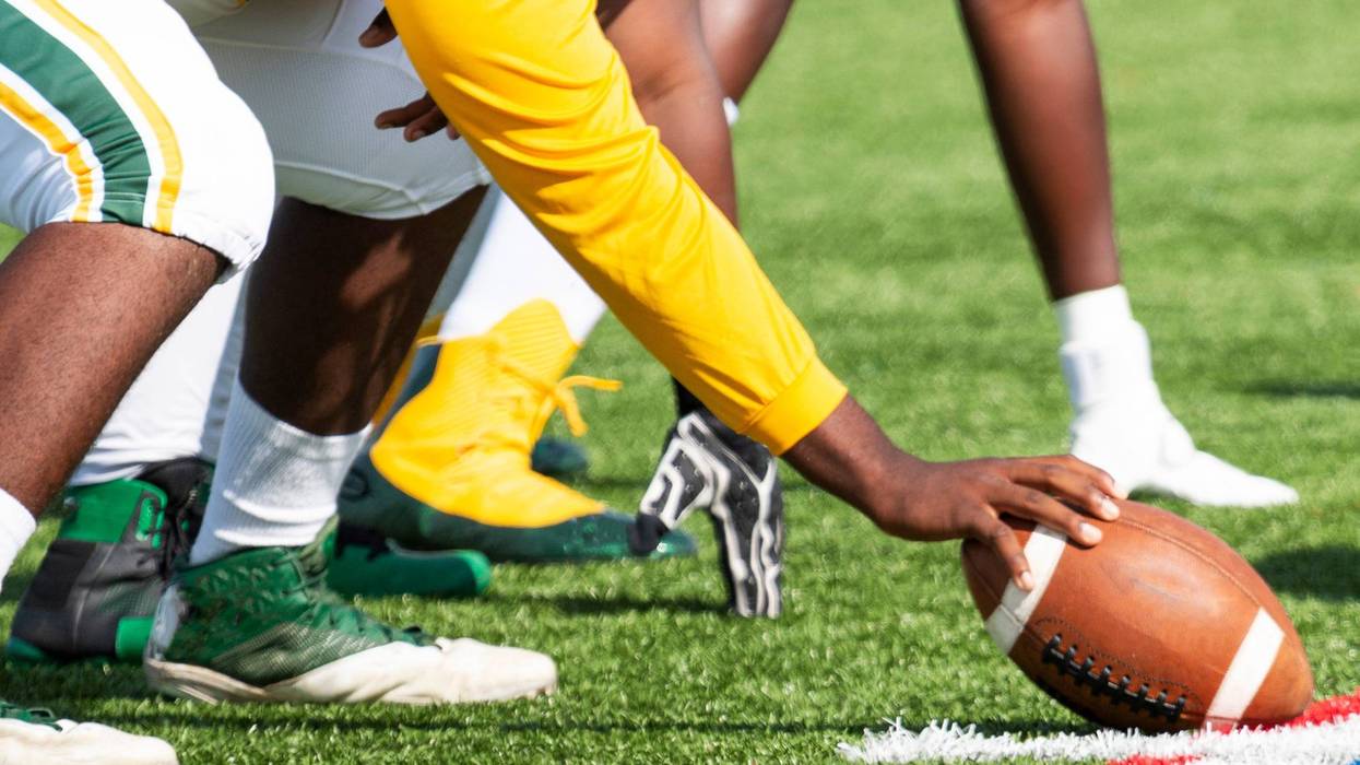 A football center readies himself to snap the ball.