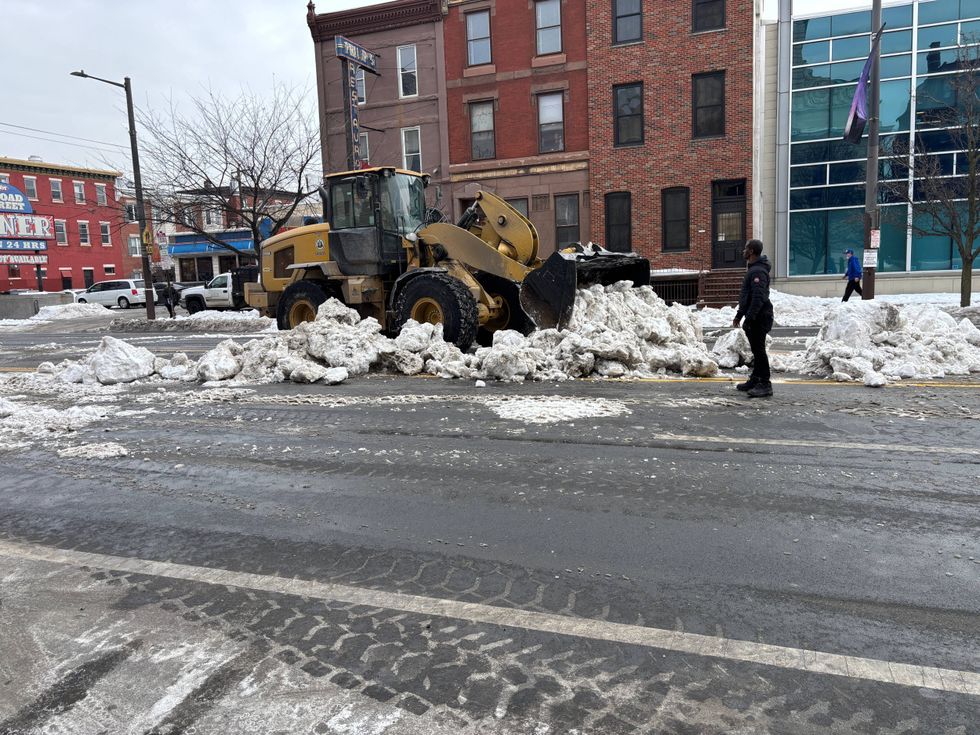 A front-load excavator moves snow on South Broad Street on Tuesday morning.