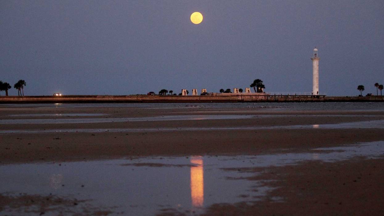 A full moon lights up the night sky at the beach in Biloxi, Mississippi.