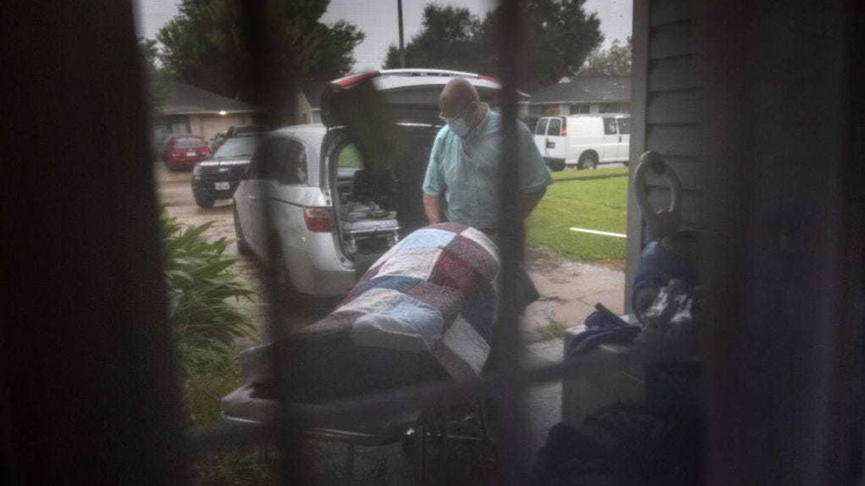A funeral home worker transports the body of a woman, 54, who died of Covid-19 in her bed at home on September 13, 2021 in Houston, Texas. She had not been vaccinated, citing fears of the vaccination shot, according to her daughter. Texas' Harris County continues to see large number of Covid-19 hospitalizations due to the Delta variant surge in the state. (Photo by John Moore/Getty Images)