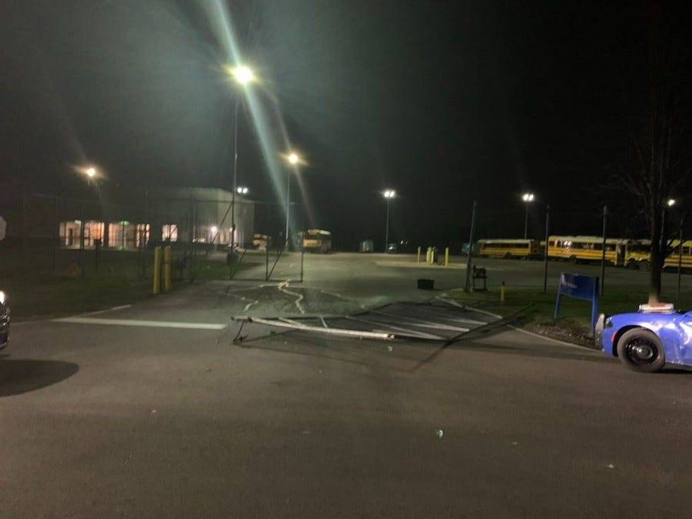 a gate is broken by a suspect who stole a school bus