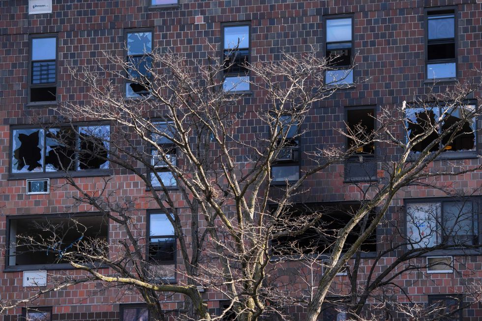 A general view shows the damaged windows of an apartment building the day after a deadly fire in the Bronx, New York on January 10, 2022.