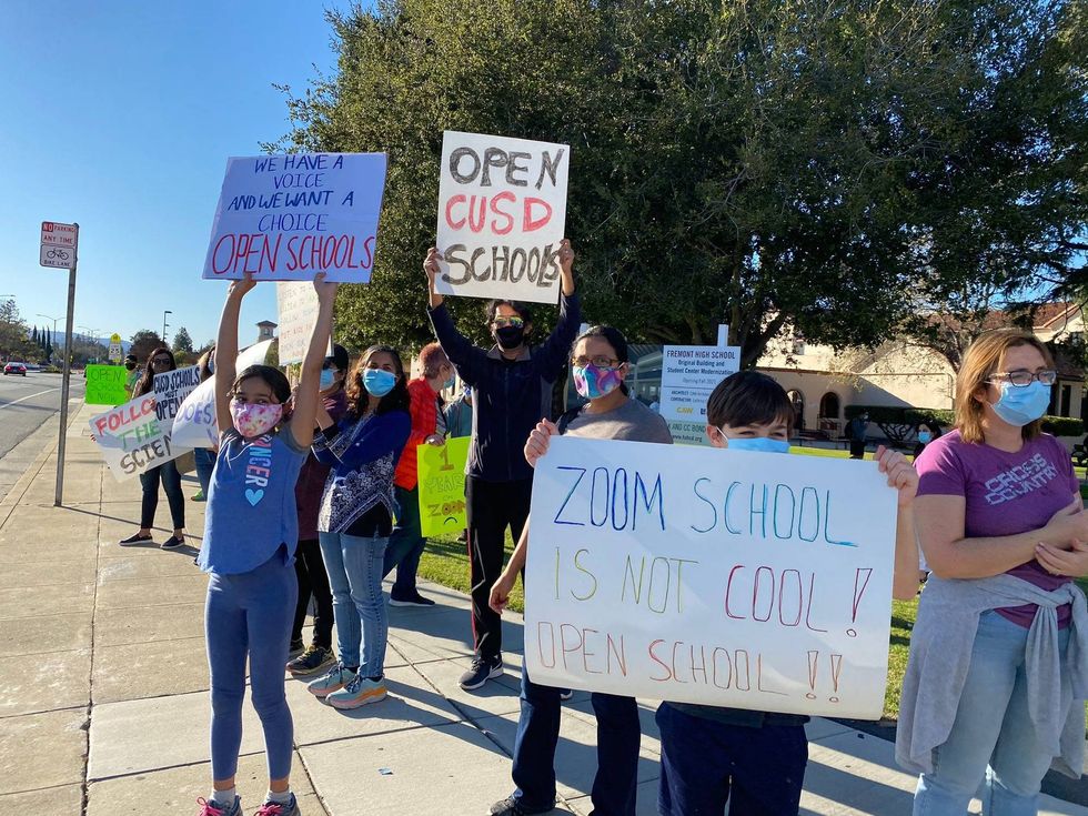 A group composed of students and parents from school districts in Sunnyvale and Cupertino protests outside Fremont High School on Tuesday afternoon.