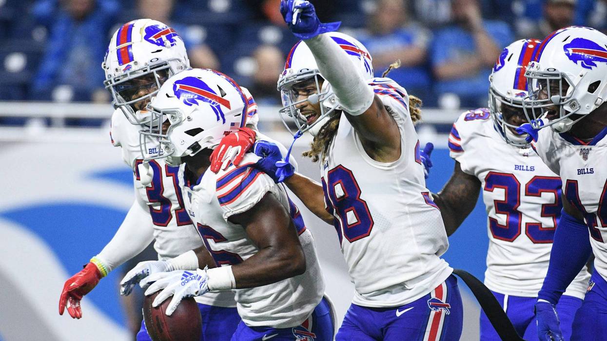 A group of Buffalo Bills players celebrate in uniform