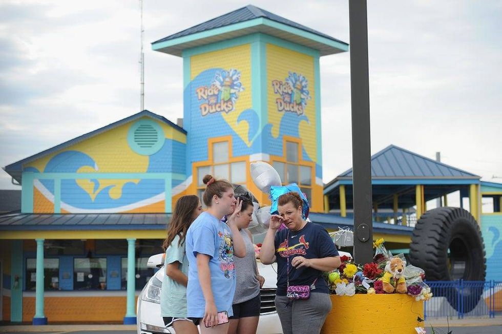 A group of mourners pause for a moment of prayer at Ride The Ducks Tours on July 20, 2018 in Branson, Missouri. Hundreds of mourners stopped by the location to pay their respects to the victims after a duck boat capsized in Table Rock Lake in a thunderstorm.