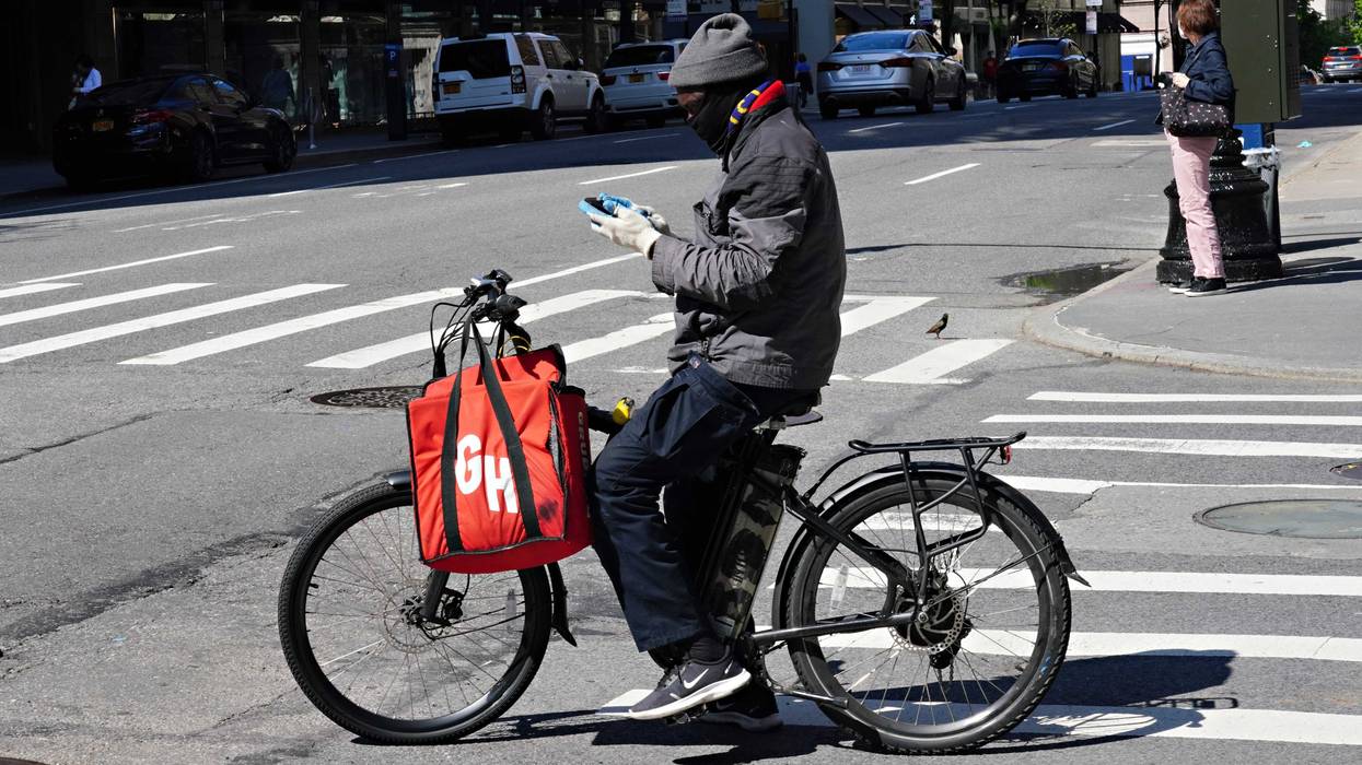 A Grubhub delivery person checks his phone during the coronavirus pandemic on May 3, 2020 in New York City.
