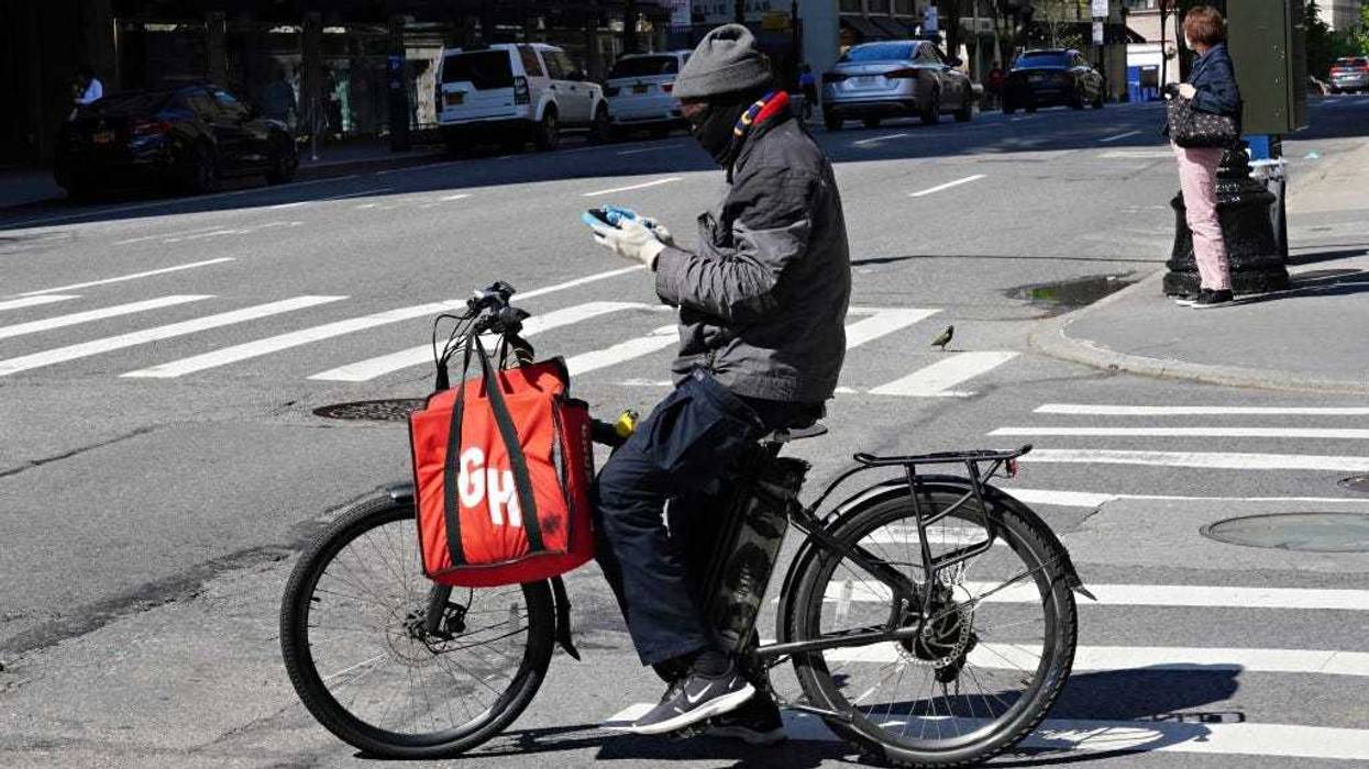 A Grubhub delivery person checks his phone during the coronavirus pandemic on May 3, 2020 in New York City.