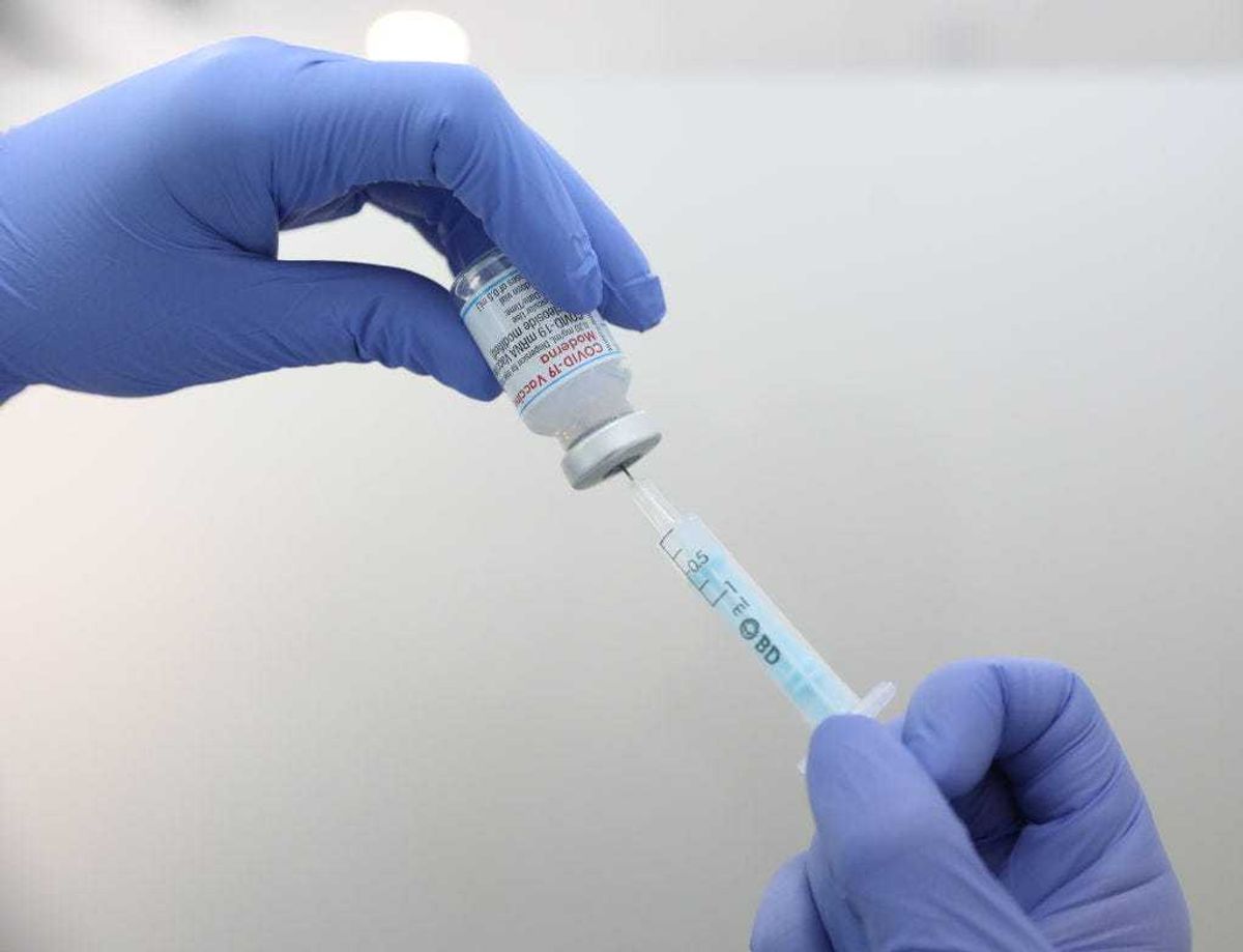 A health professional holds a vial of Moderna's vaccine against COVID-19.