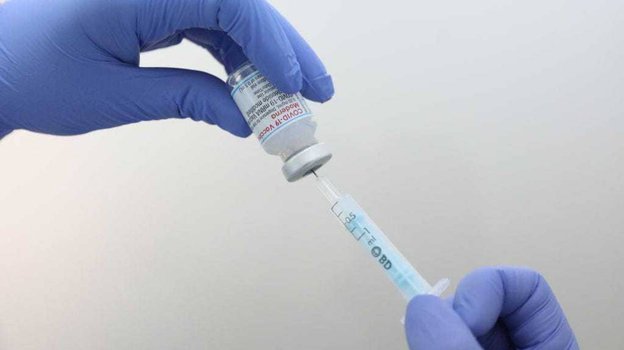A health professional holds a vial of Moderna's vaccine against COVID-19.