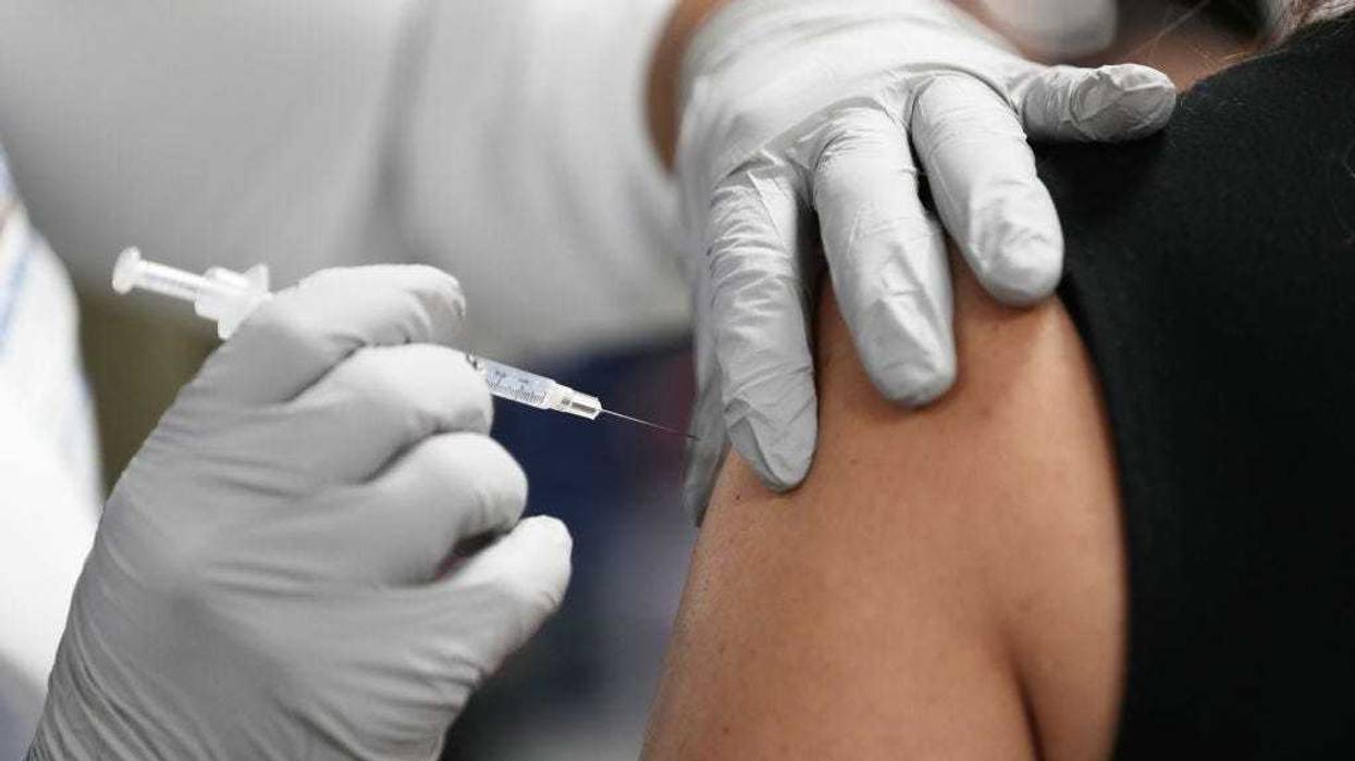 A healthcare worker at the Jackson Health Systems receives a Pfizer-BioNtech Covid-19 vaccine from Susana Flores Villamil, RN from Jackson Health Systems, at the Jackson Memorial Hospital on December 15, 2020 in Miami, Florida.