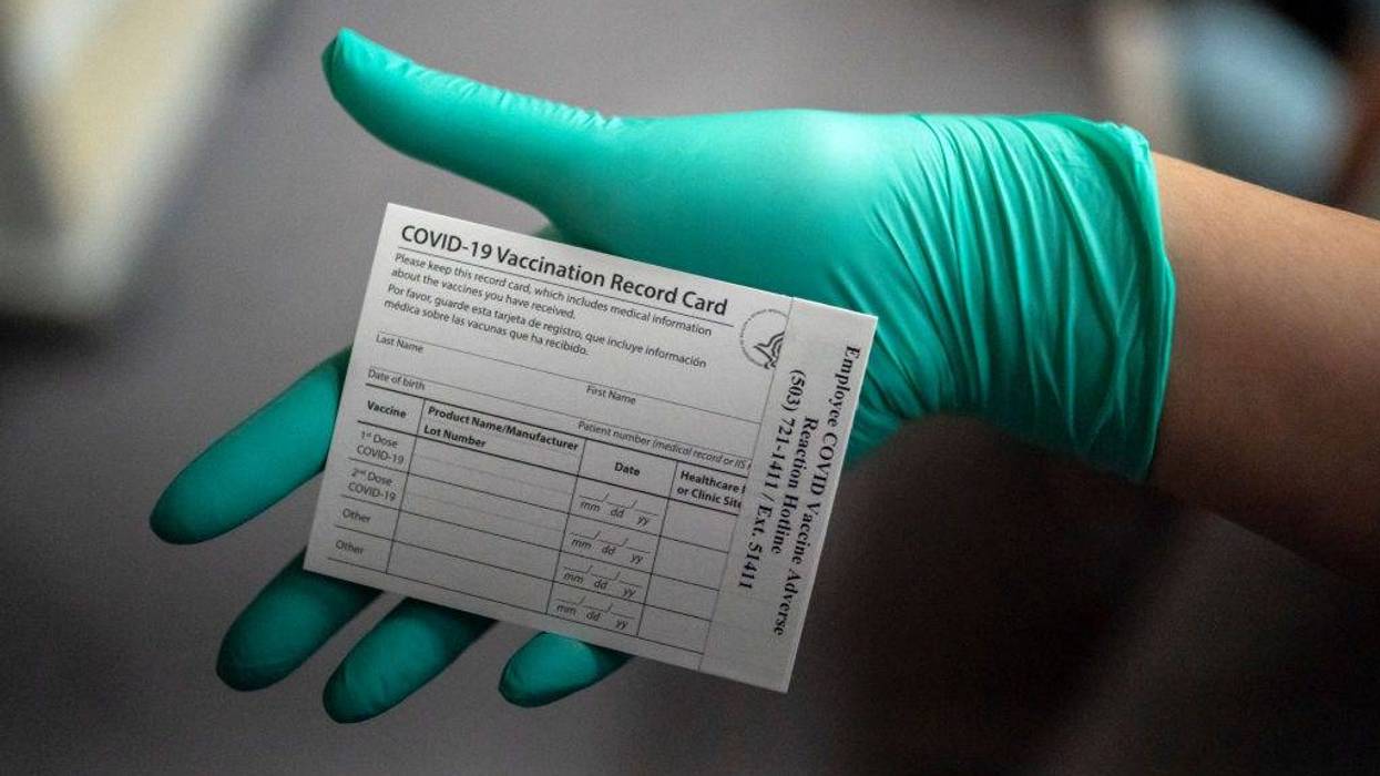 A healthcare worker displays a COVID-19 vaccine record card at the Portland Veterans Affairs Medical Center on December 16, 2020 in Portland, Oregon.