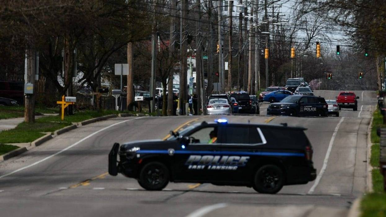 A heavy police presence and crime scene tape near West Holmes Road and Simken Drive in Lansing, Wednesday, April 10, 2024.