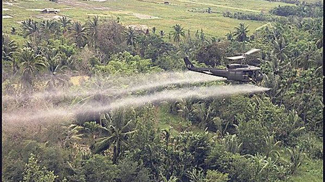 A helicopter sprays herbicide over Vietnam.