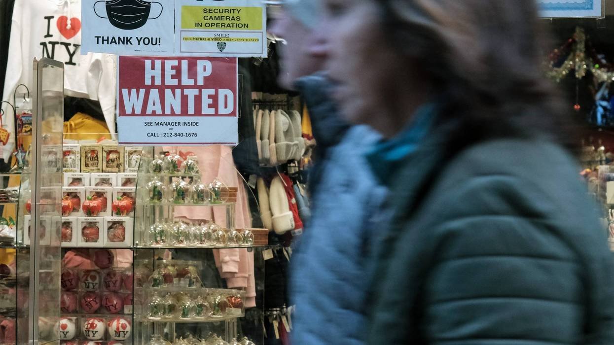A "help wanted" sign is displayed in a window of a store