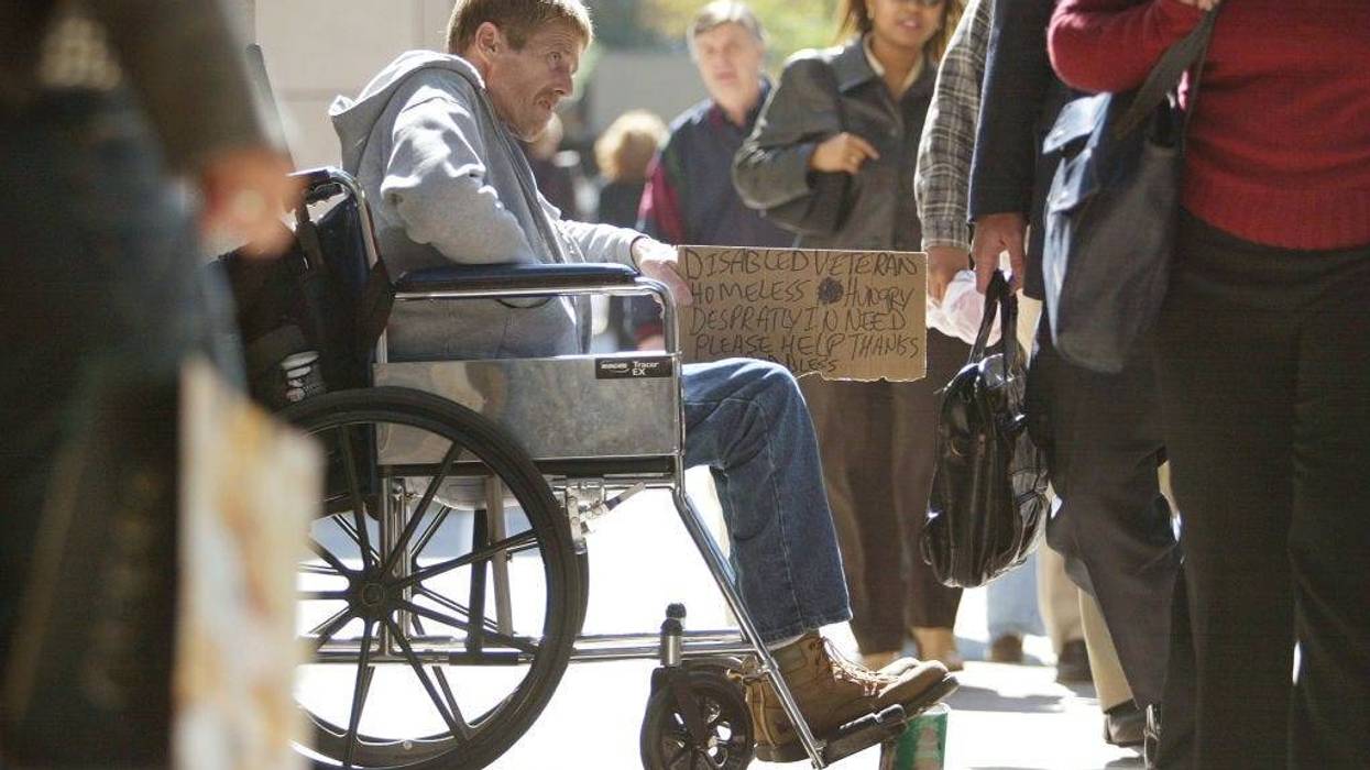 A homeless, disabled veteran in his wheelchair is surrounded by pedestrians as he is looking for money along the shopping area known as the "Magnificent Mile" on Michigan Ave. September 30, 2004 in Chicago.