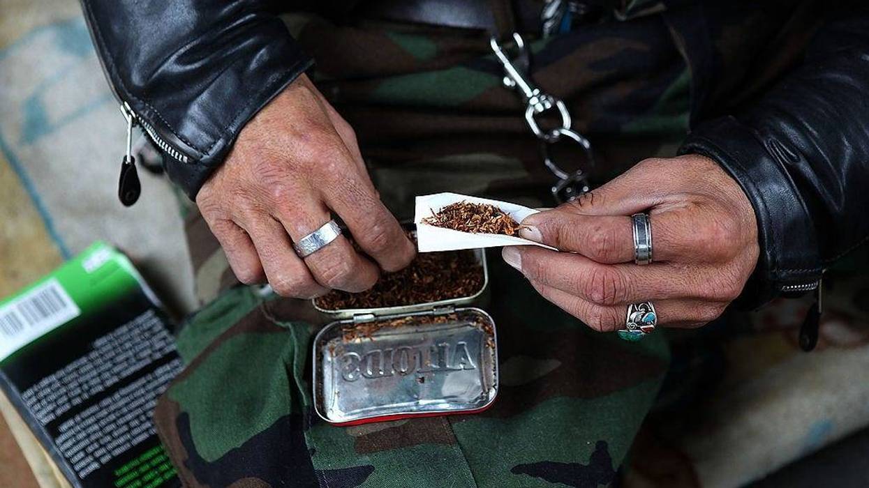A homeless man named Joe hand rolls a cigarette while sitting under a freeway overpass January 25, 2010 in San Francisco, California.