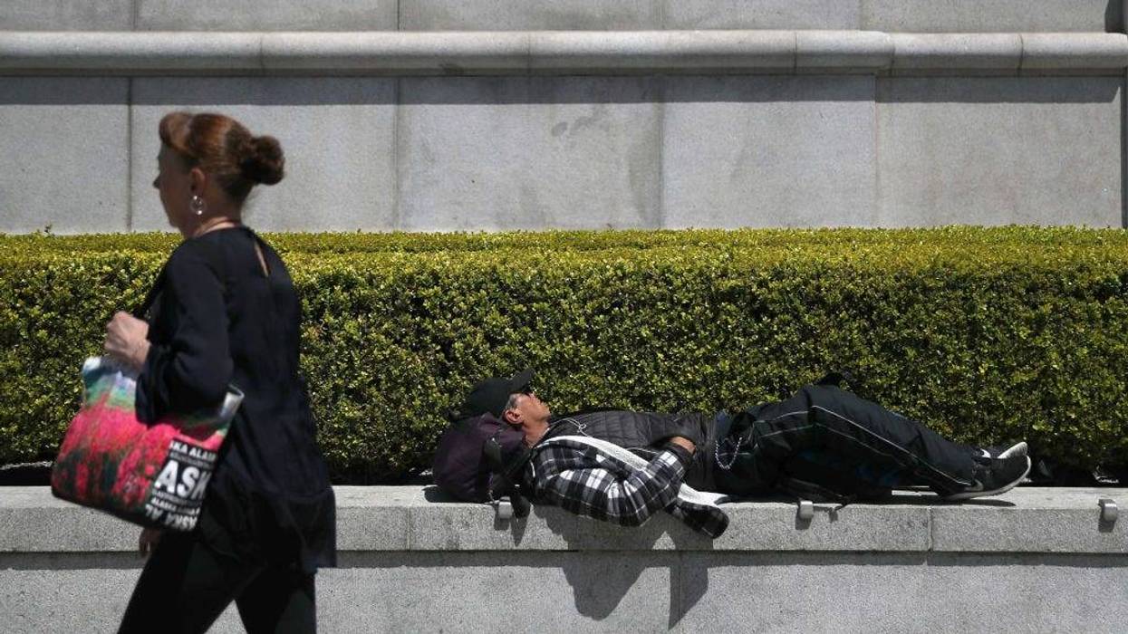 A homeless man sleeps outside of the Asian Art Museum on May 17, 2019 in San Francisco, California.