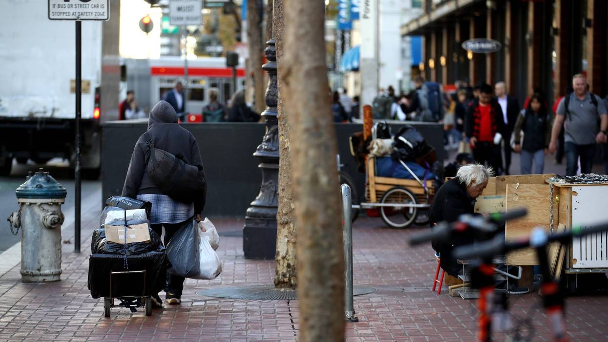 A homeless man spulls a cart with his belongings on November 25, 2019 in San Francisco.