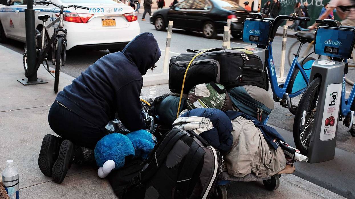 A homeless woman panhandles on the street in New York City.